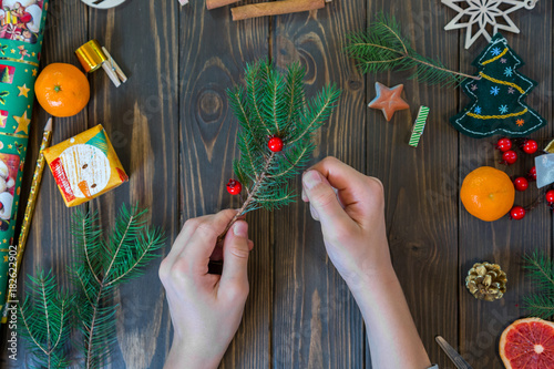 boy's hands decorate tree with berry on the wooden background. New Year and Christmas concept. flat lay. top view photo