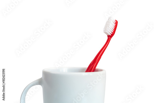 Close-up of Red Plastic Toothbrush in White Mug Isolated on White Background Concept Dental