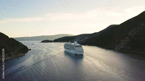 White cruise ship floats through narrow straits of Verige between mountains. Aerial view photo