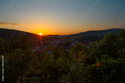 Beautiful landscape of sunrise over small town in forest mountains. Romania, Sighisoara - 2016.