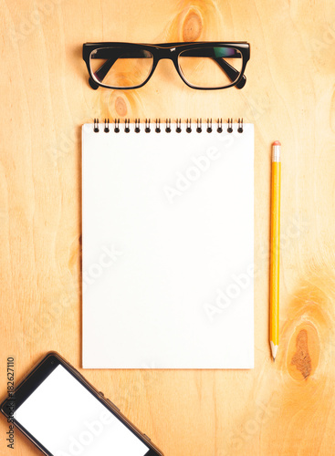 Business essentials. Top view of spiral blank notebook.