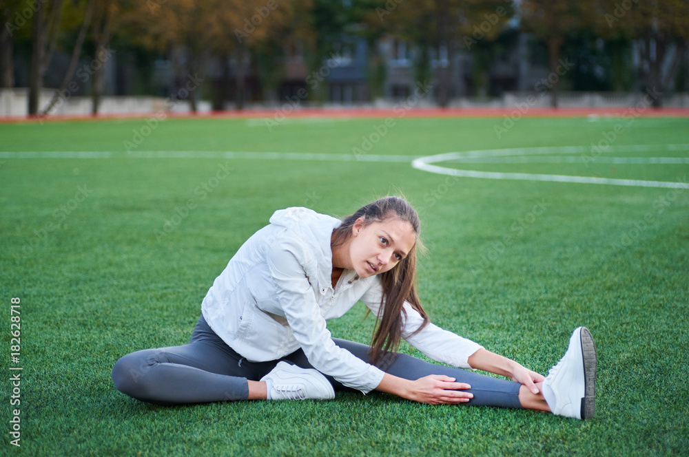Fototapeta premium Athletic woman stretching her leg