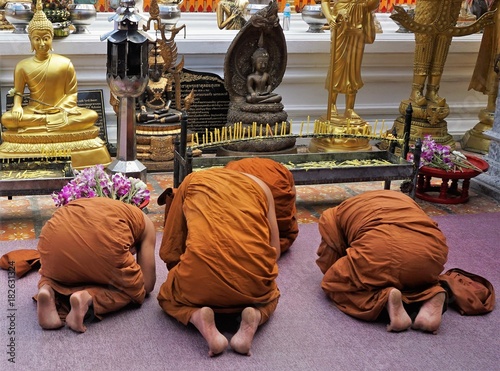 Monks praying and worshipping in front of temple in Thailand