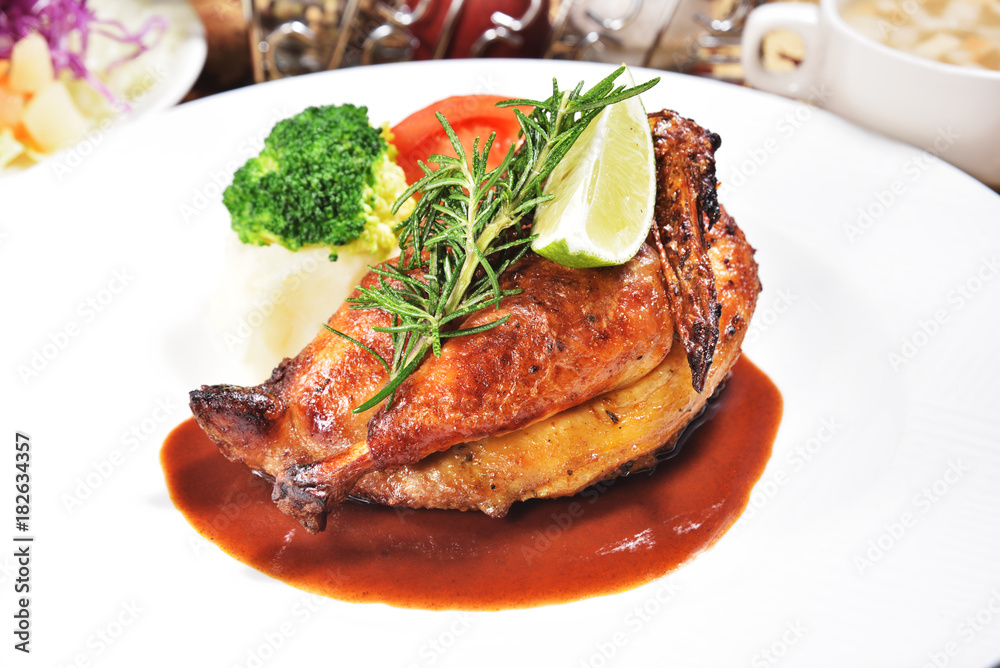 Half of appetizing roasted juicy chicken with lemon slices and vegetables Half of appetizing roasted juicy chicken with lemon slices and vegetables