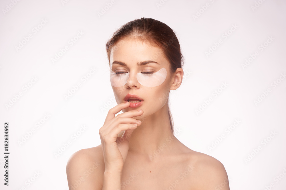 woman with closed eyes under eyes patches on skin care on a light background portrait woman with closed eyes under eyes patches on skin care on a light background portrait
