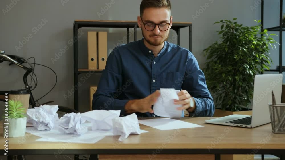 Portrait of angry man in the glasses trying to write a business plan ...