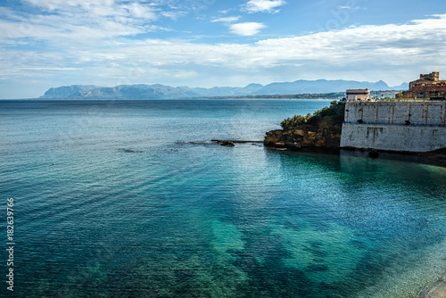 Coastline with crystal clear blue waters under blue skies and wh