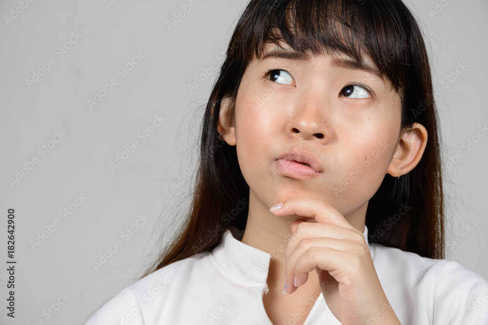 Portrait of beautiful young Asian woman against white background Portrait of beautiful young Asian woman against white background