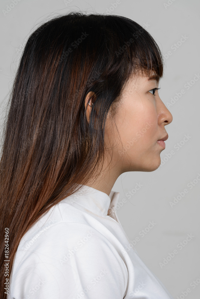 Portrait of beautiful young Asian woman against white background Portrait of beautiful young Asian woman against white background