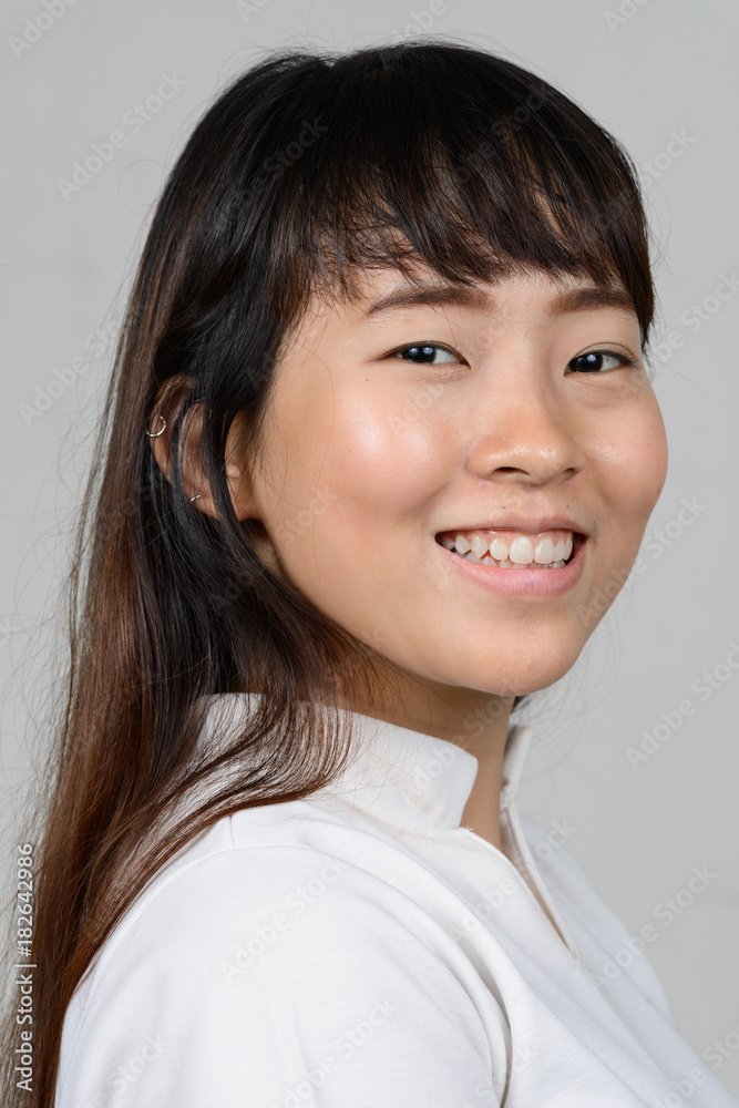 Portrait of beautiful young Asian woman against white background Portrait of beautiful young Asian woman against white background