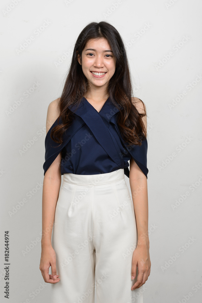 Portrait of young beautiful Asian woman against white background Portrait of young beautiful Asian woman against white background