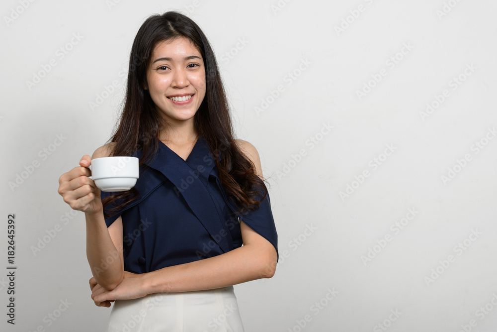 Happy woman smiling and holding coffee cup Happy woman smiling and holding coffee cup