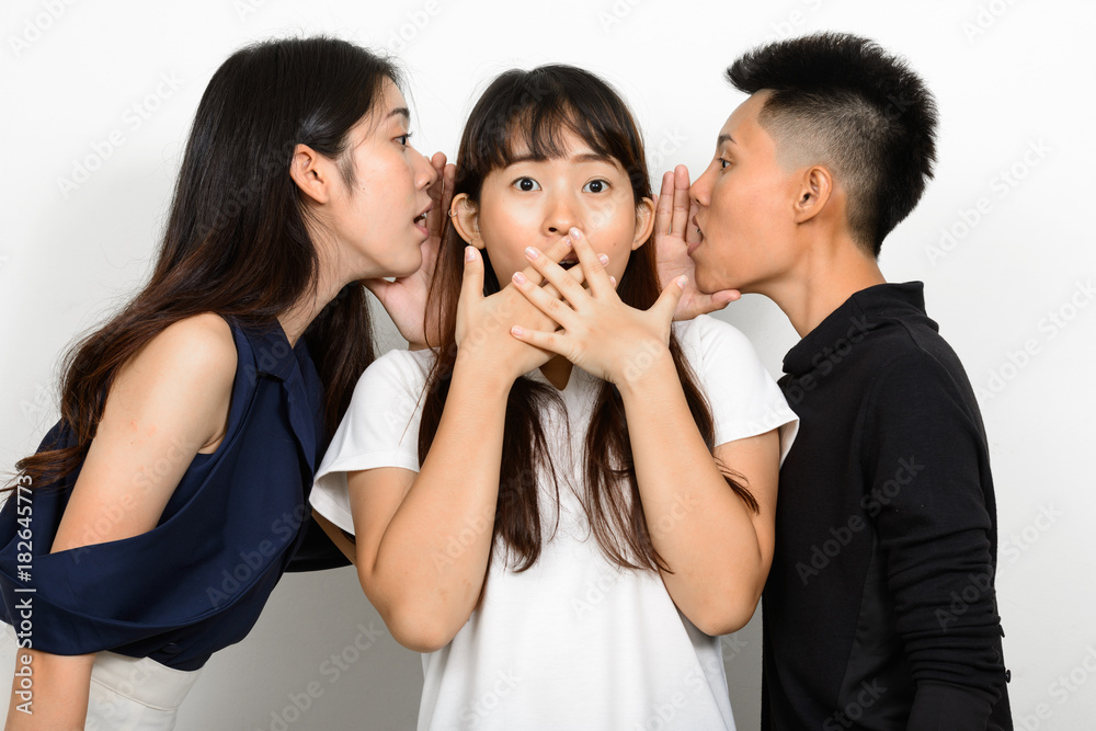 Group Of Three Young Asian Woman Indoors Against White Background Group Of Three Young Asian Woman Indoors Against White Background