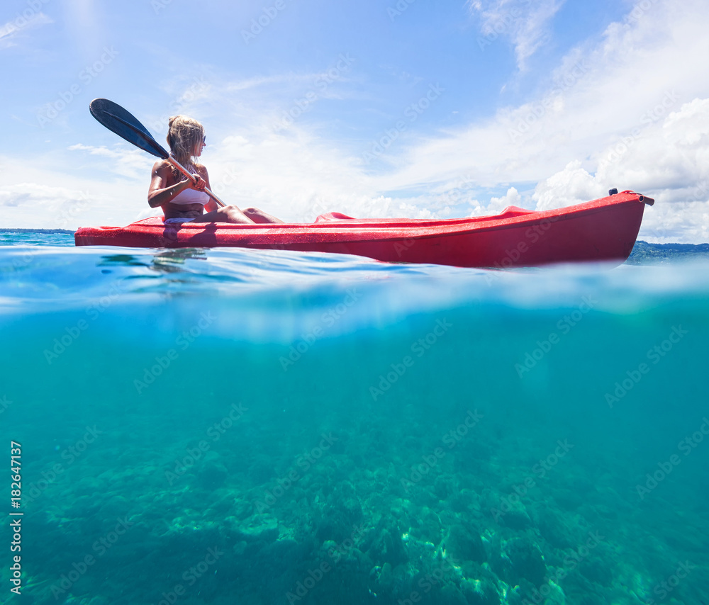 Fototapeta premium Woman in white swimwear on kayak explore blue sea. Split photo. Selective focus.