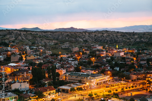 Top view. A small authentic city called Goreme in Cappadocia in Turkey in the evening. Dramatic night sky, sunset. © franz12
