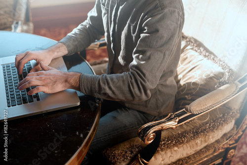 A young businessman uses a laptop in an expensive office. photo