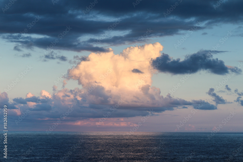 Sunset with large cloud over the sea along coast of Kauai