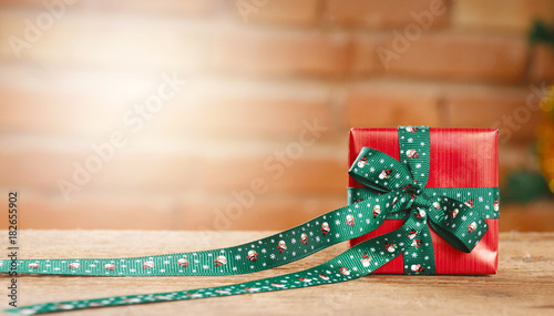 Closeup of a red gift box on blurred bricks on background