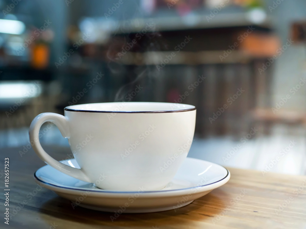 Hot coffee, white cup of espresso on wood table with blur background of sunlight in cafe or coffeeshop.