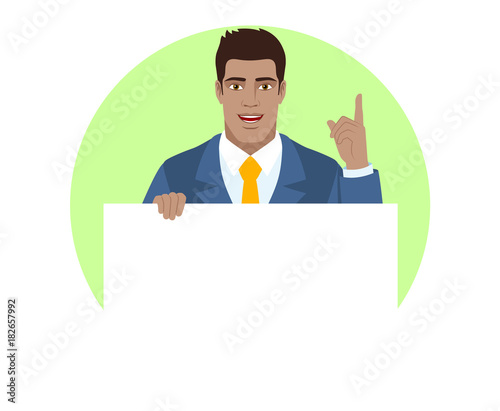 Businessman holding white blank poster and pointing up