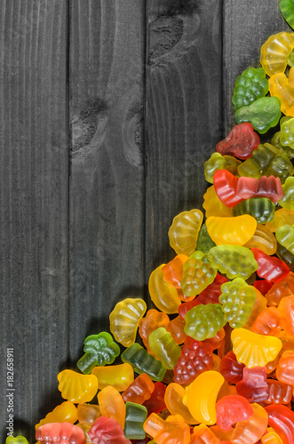 Obraz na płótnie jelly and marmalade candies on a wooden background with free space for text