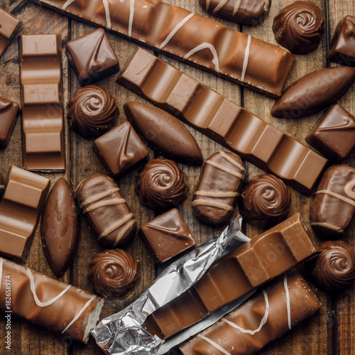 Background of chocolates, bars and sweets, free space for text, close up