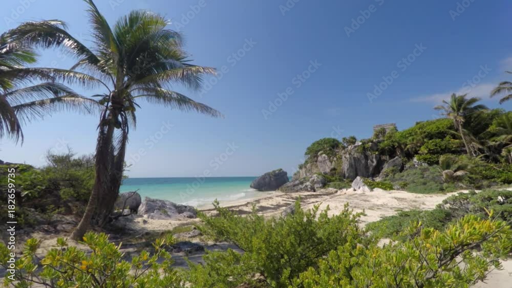 Mayan ruin at Tulum on coastline near Cancun in jungle panning shot Mayan ruin at Tulum on coastline near Cancun in jungle panning shot