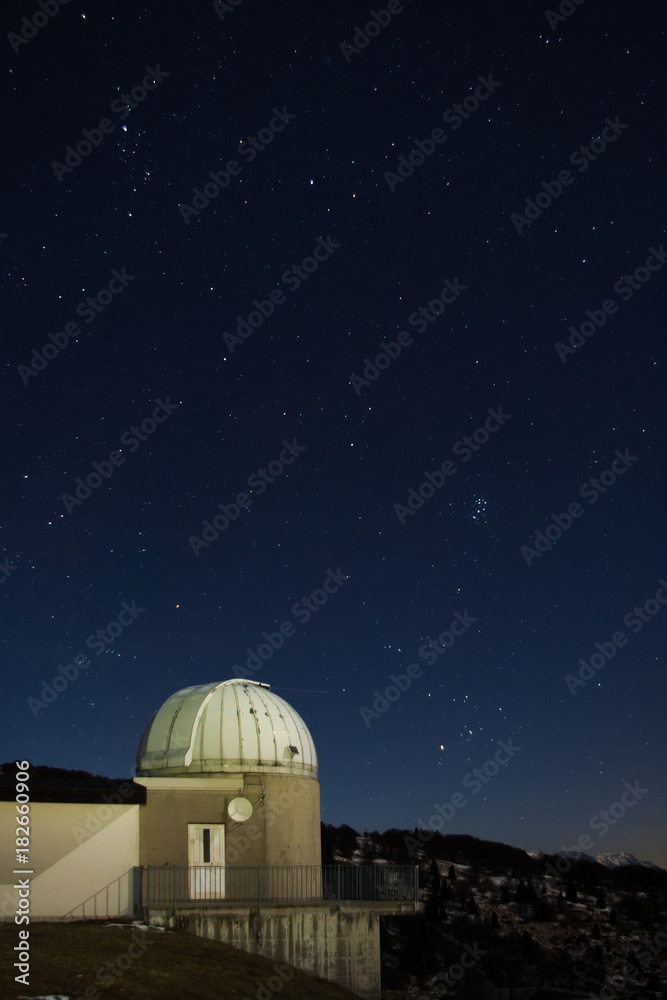Astronomical observatory under the night sky and stars on the Matajur mountain, close to the border between Italy and Slovenia
