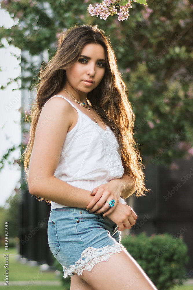 Girl modeling fashionable clothes in the park, summer. teal and orange style Girl modeling fashionable clothes in the park, summer. teal and orange style