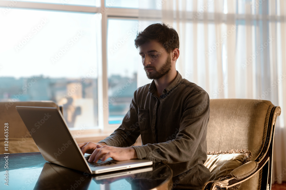 Seriously and young hipster guy using laptop computer, person work at home. Seriously and young hipster guy using laptop computer, person work at home.