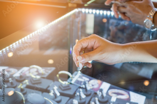 Asian woman choosing wedding rings at jewelry diamond shop photo