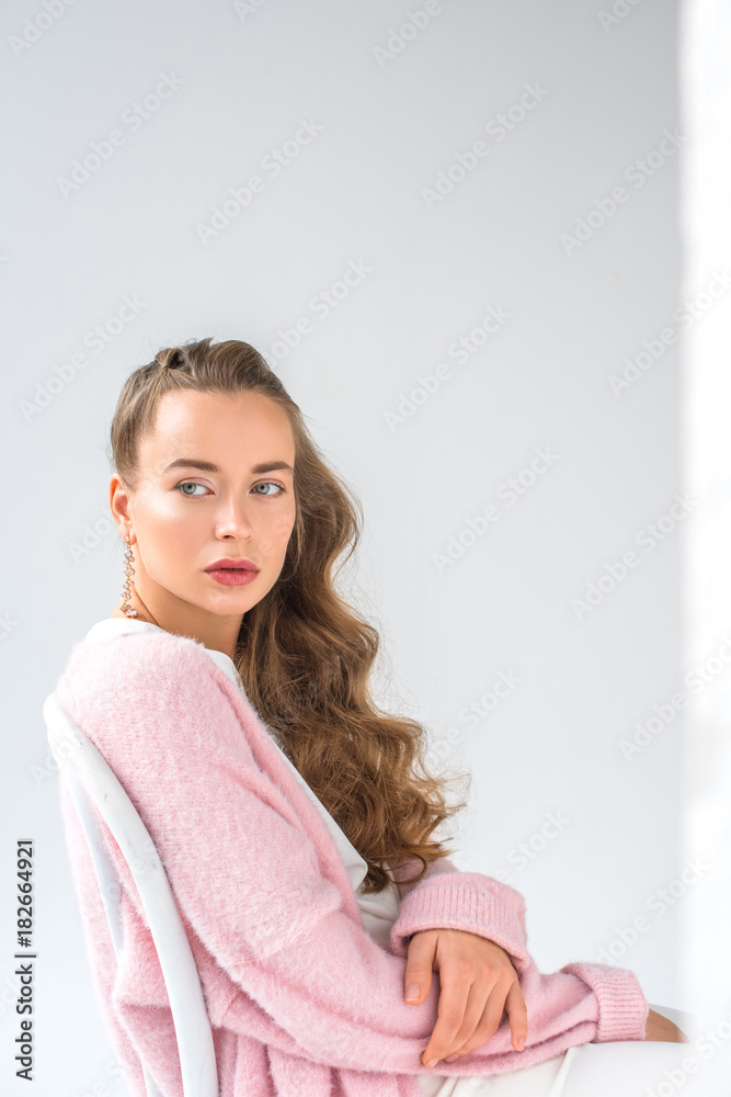beautiful girl with makeup sitting on chair and looking away on white beautiful girl with makeup sitting on chair and looking away on white