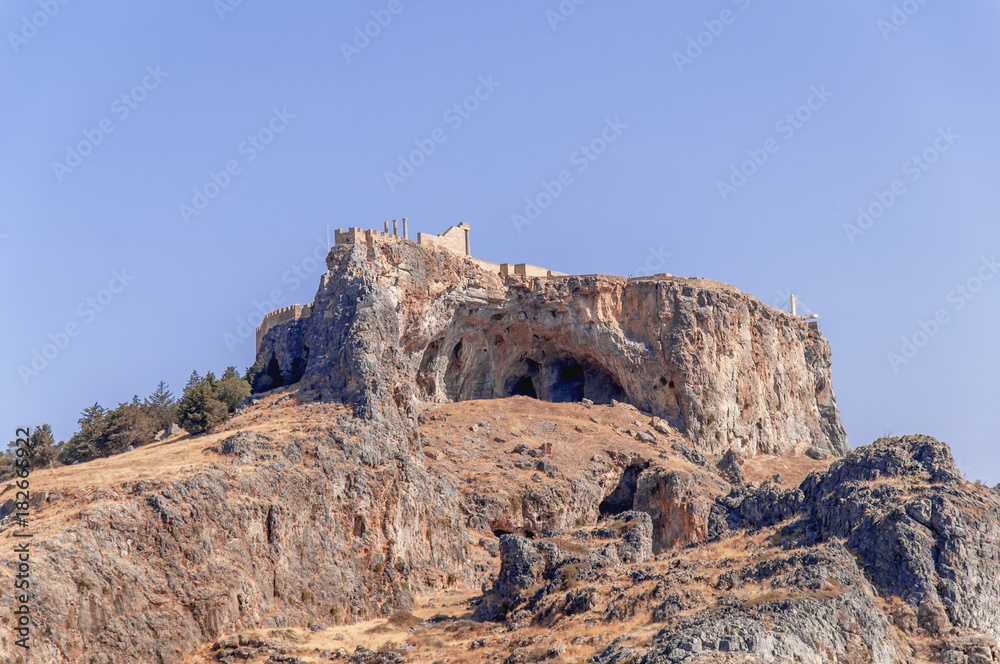 Summer bottom cliff view Acropolis of Lindos of Rhodes with big blue clean sky