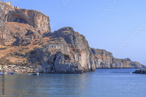 Summer bottom cliff view of Rhodes Acropolis of Lindos with sea