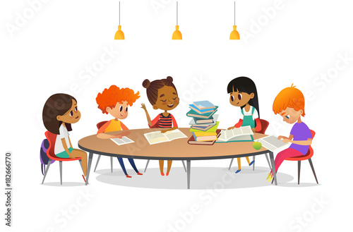 Multiracial children sitting around round table with pile of books on it and listening to girl reading aloud. School literature club. Cute cartoon characters. Vector illustration for banner, poster.