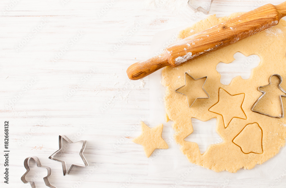 Cut the cookie shape from the dough at the white table. View with copy space Cut the cookie shape from the dough at the white table. View with copy space