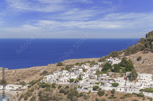 Summer bottom view of Rhodes Acropolis of Lindos with sea and cludy sky