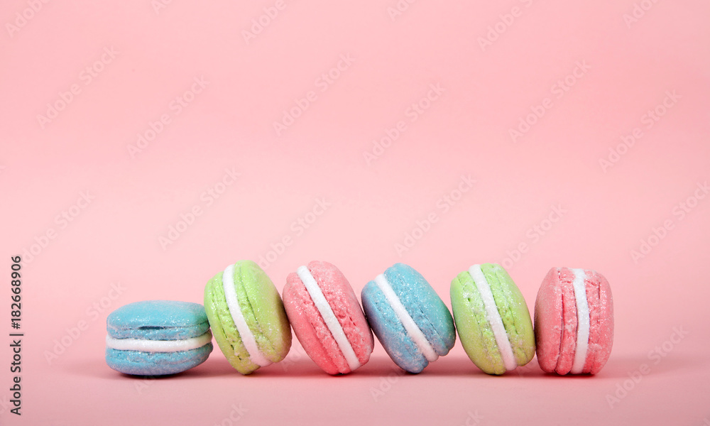 Large Macaroon cookies covered in granulated sugar on a table. pink background. Popular pastry in France. Large Macaroon cookies covered in granulated sugar on a table. pink background. Popular pastry in France.