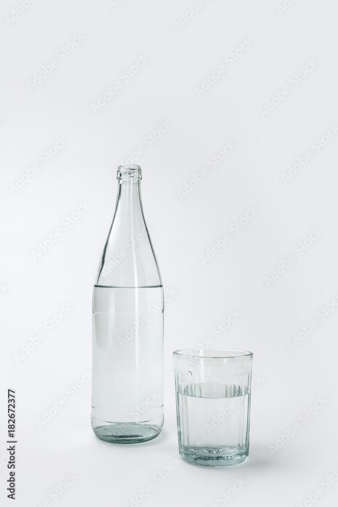 bottle and glass with mineral water isolated on white