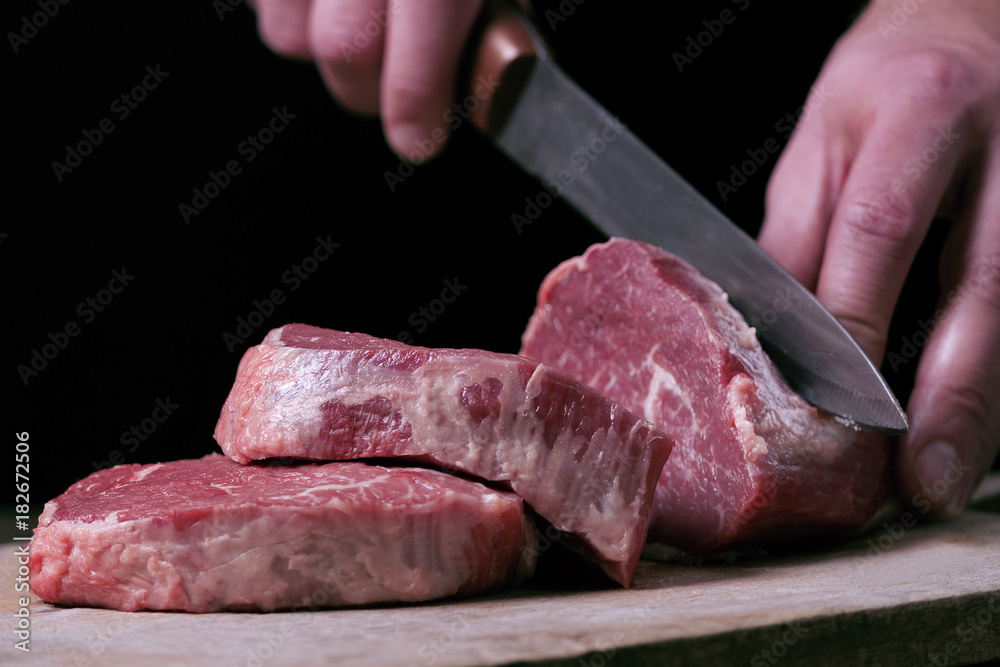 Butcher cutting beaf meat on kitchen. Food background
