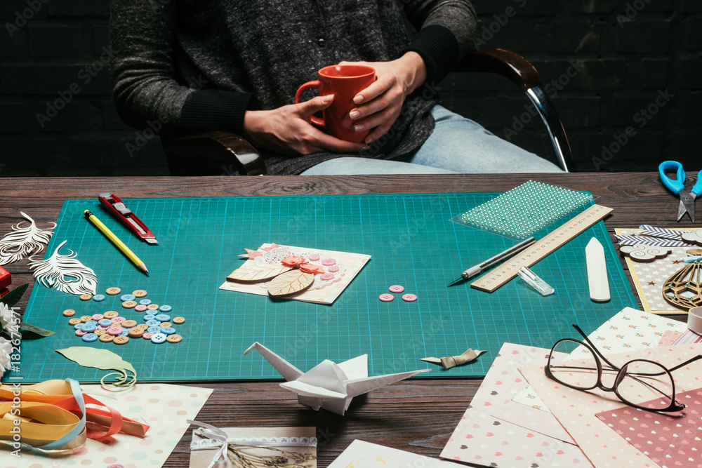 Obraz premium cropped image of woman sitting and holding cup of coffee in hands