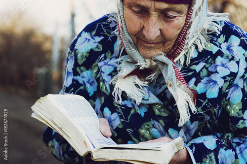 The old grandmother is reading a book-Bible