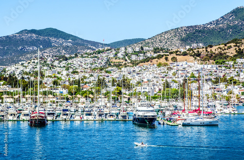 Many yachts moored in the bay of Bodrum against the background of the city and mountains.