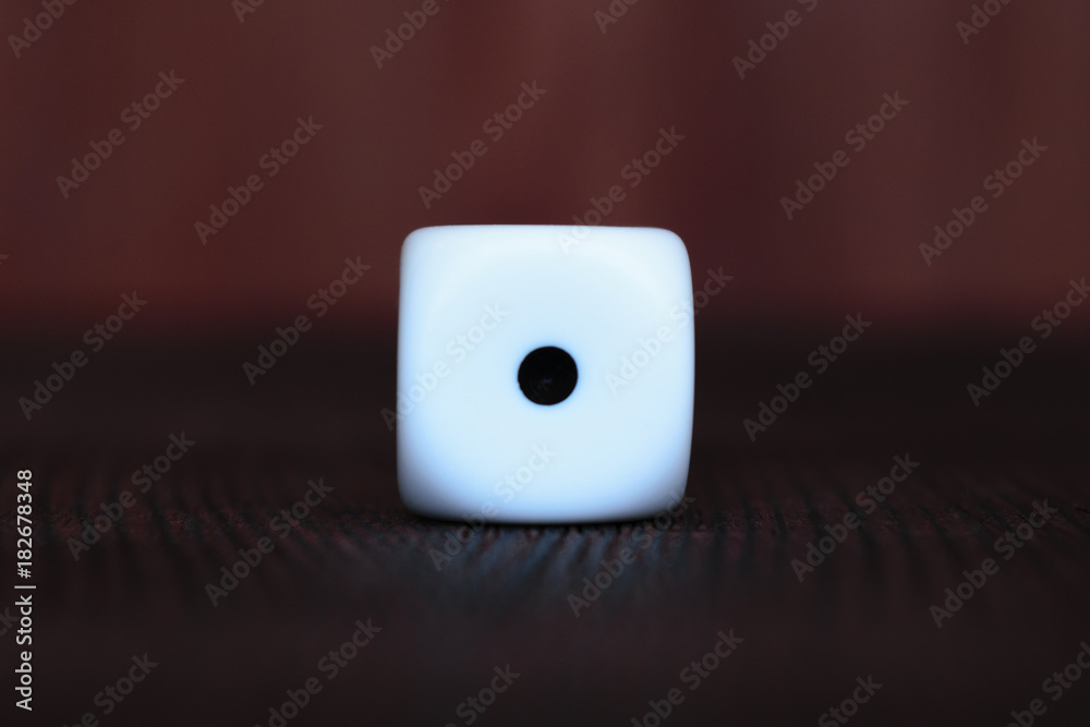 Single white plastic dice on brown wooden board background. Six ...