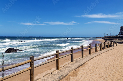 Wooden Pole Barrier on Beachfront Against Coastal Landscape