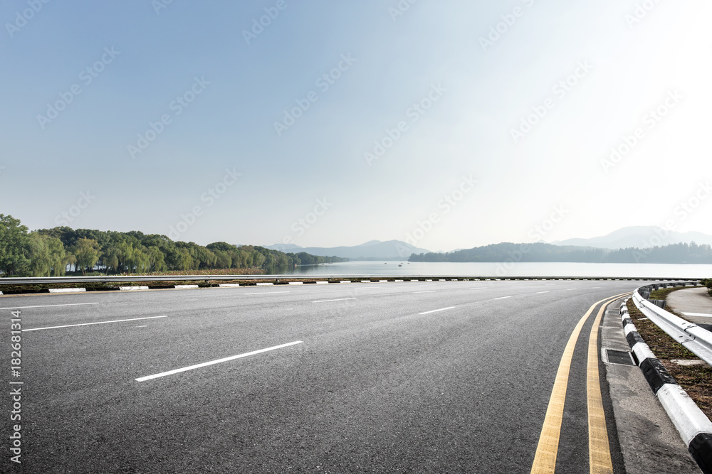 Fototapeta premium empty asphalt road with beautiful lake