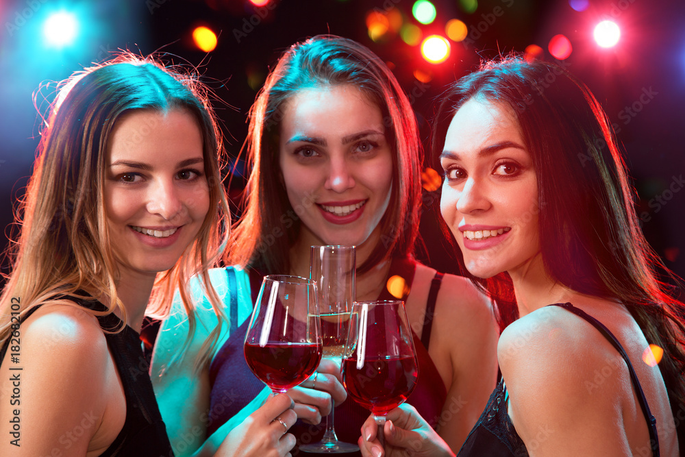 Happy young women with glasses of wine