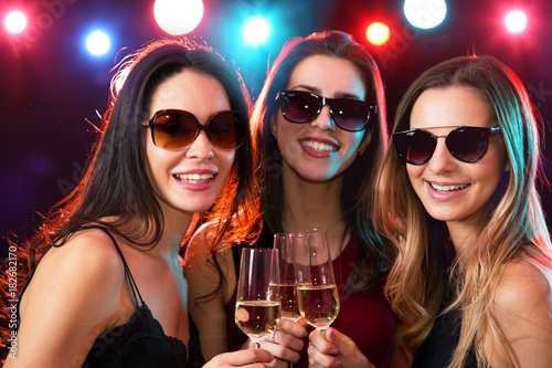 Happy young women with glasses of wine