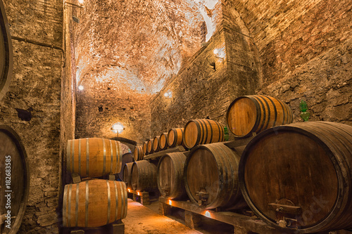 Fotografie Wooden barrels with wine in a wine vault