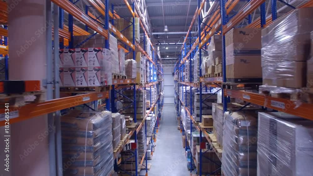 Camera moving straight between warehouse racking rows. Camera moving straight between warehouse racking rows.